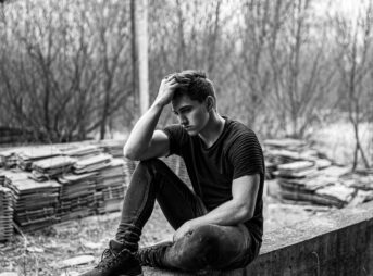 Man Sitting On Concrete Bench