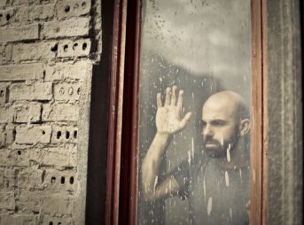 man leaning on window