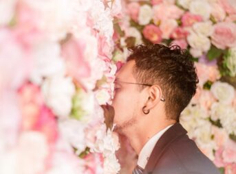 man leaning on flower wall