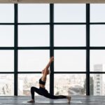 woman in black tank top and black leggings doing yoga