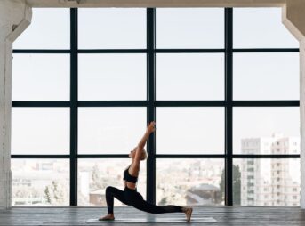 woman in black tank top and black leggings doing yoga