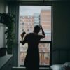 man standing by the window beside bed